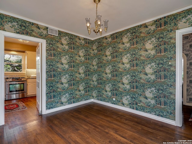 unfurnished dining area featuring crown molding, dark hardwood / wood-style floors, and an inviting chandelier