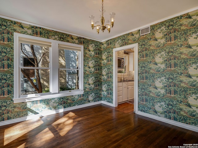 unfurnished dining area with crown molding, sink, an inviting chandelier, and dark hardwood / wood-style floors