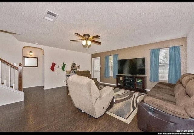 living room with ceiling fan, dark hardwood / wood-style floors, and a textured ceiling