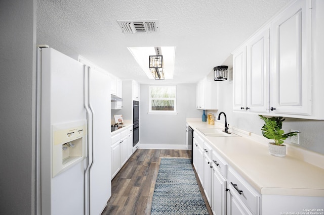 kitchen featuring sink, white cabinetry, a textured ceiling, dark hardwood / wood-style flooring, and black appliances