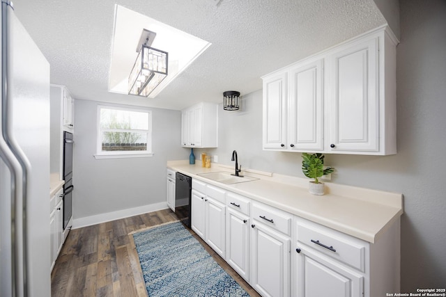 kitchen with sink, white cabinetry, a textured ceiling, fridge, and black dishwasher