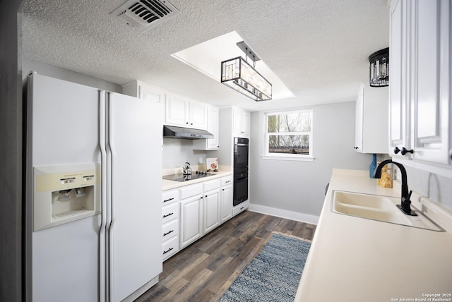 kitchen featuring sink, black appliances, a textured ceiling, dark hardwood / wood-style floors, and white cabinets