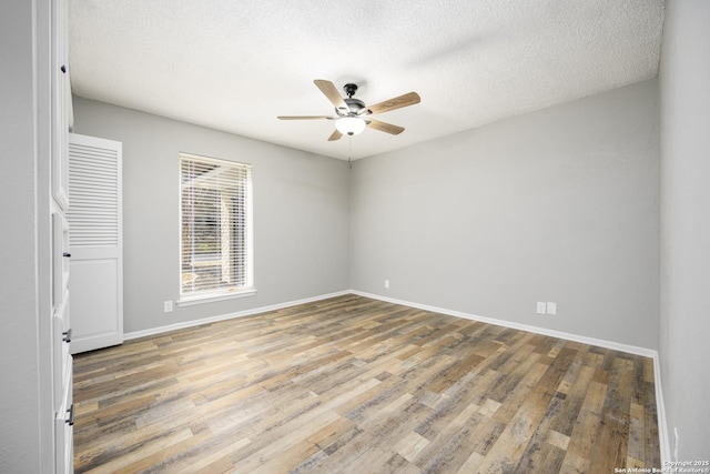 empty room featuring hardwood / wood-style flooring, a textured ceiling, and ceiling fan