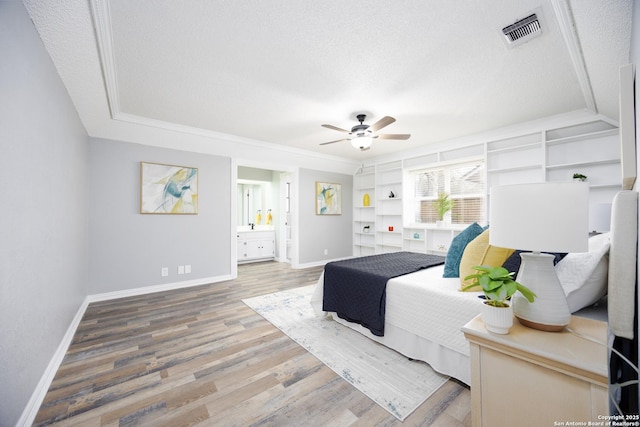 bedroom featuring hardwood / wood-style flooring, ceiling fan, a textured ceiling, and ensuite bath