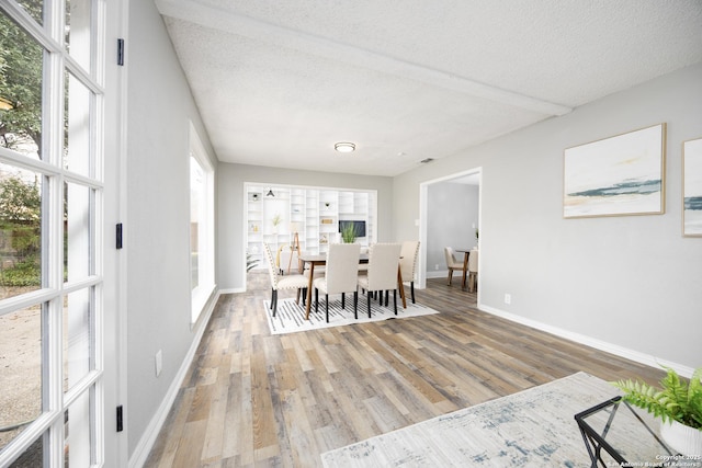 dining room with hardwood / wood-style flooring and a textured ceiling