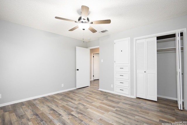 unfurnished bedroom with hardwood / wood-style flooring, ceiling fan, a textured ceiling, and a closet