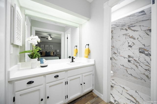 bathroom featuring vanity, toilet, and tiled shower