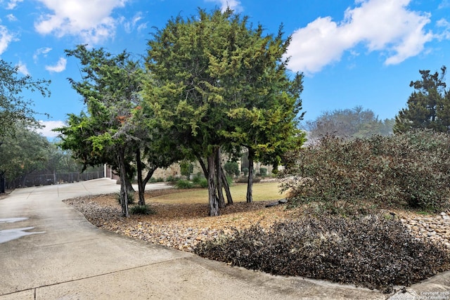 view of community featuring driveway and fence