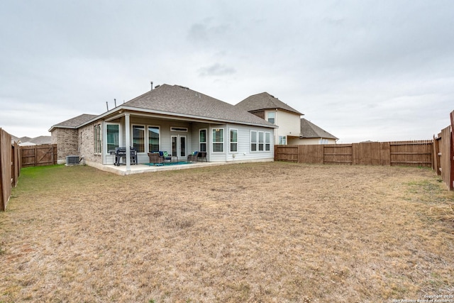 back of property featuring central AC unit, a lawn, and a patio