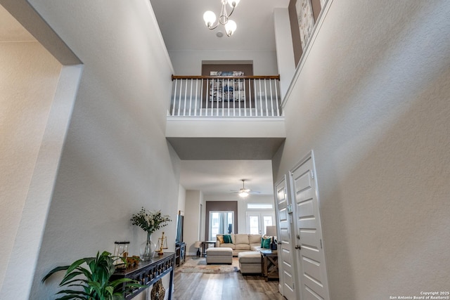 foyer featuring a notable chandelier, wood-type flooring, and a high ceiling