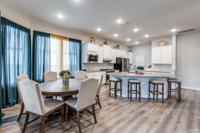 dining room with sink and light hardwood / wood-style floors