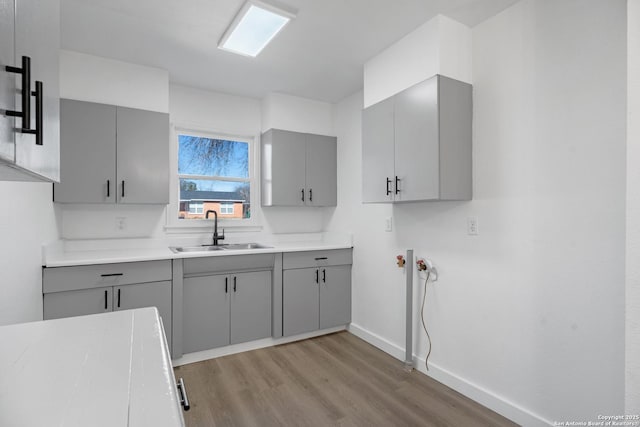 kitchen featuring light wood-type flooring, sink, and gray cabinetry