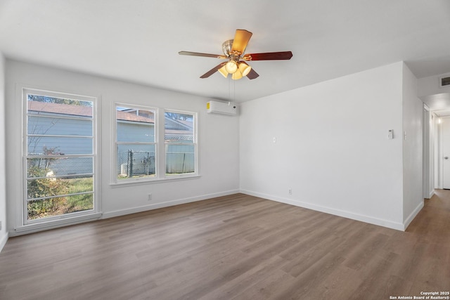 unfurnished room with ceiling fan, a healthy amount of sunlight, light wood-type flooring, and an AC wall unit