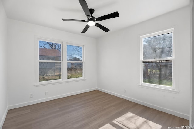 spare room featuring ceiling fan, light hardwood / wood-style floors, and a healthy amount of sunlight