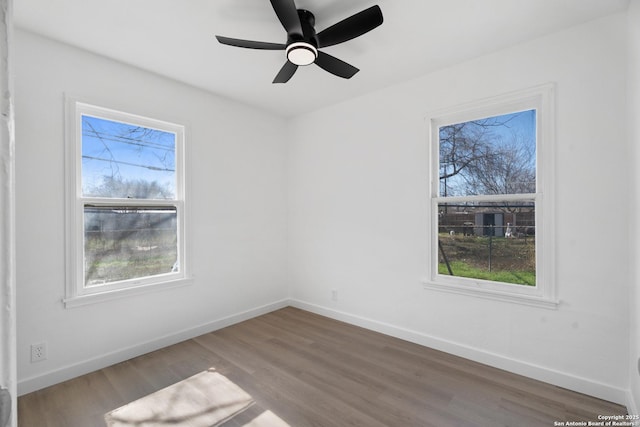 unfurnished room featuring ceiling fan, hardwood / wood-style floors, and a wealth of natural light