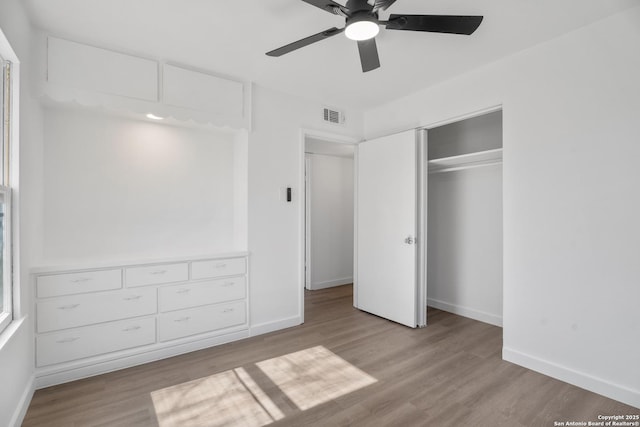 unfurnished bedroom featuring ceiling fan, light hardwood / wood-style floors, and a closet