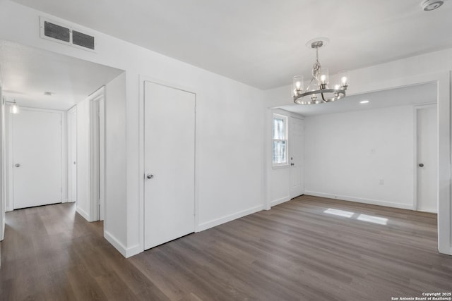 unfurnished dining area featuring dark hardwood / wood-style flooring and a chandelier