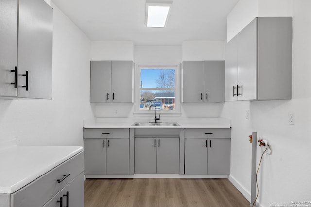 kitchen featuring gray cabinets, sink, and light hardwood / wood-style flooring