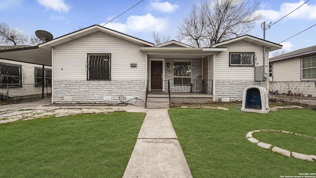 view of front of house featuring a carport, covered porch, and a front lawn