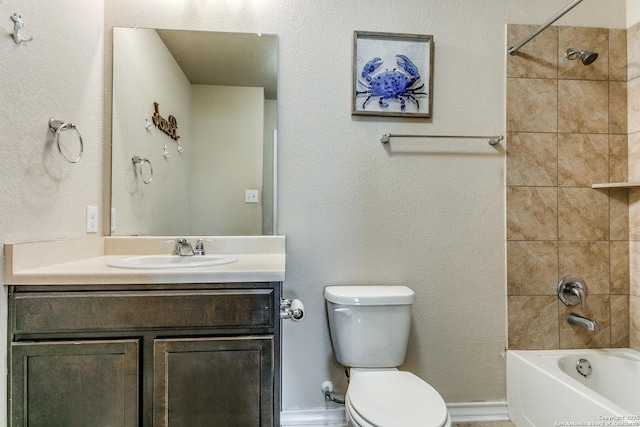 full bathroom featuring vanity, tiled shower / bath, and toilet