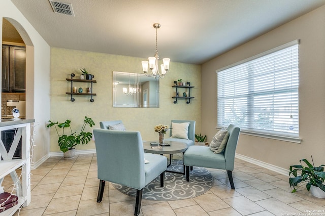 tiled dining space with a chandelier