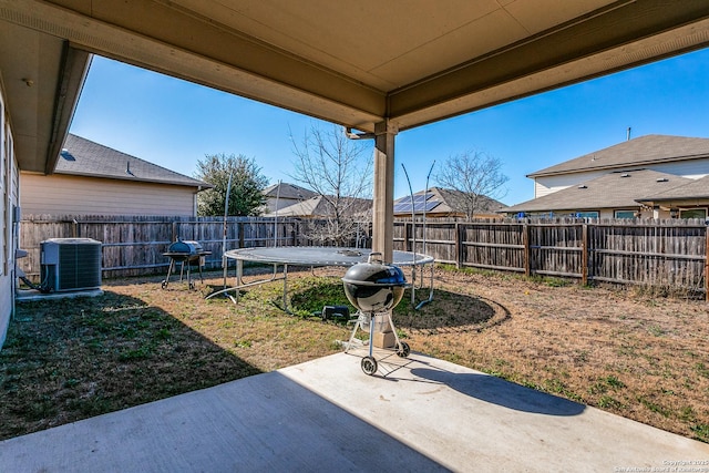 view of yard with central AC, a patio, and a trampoline