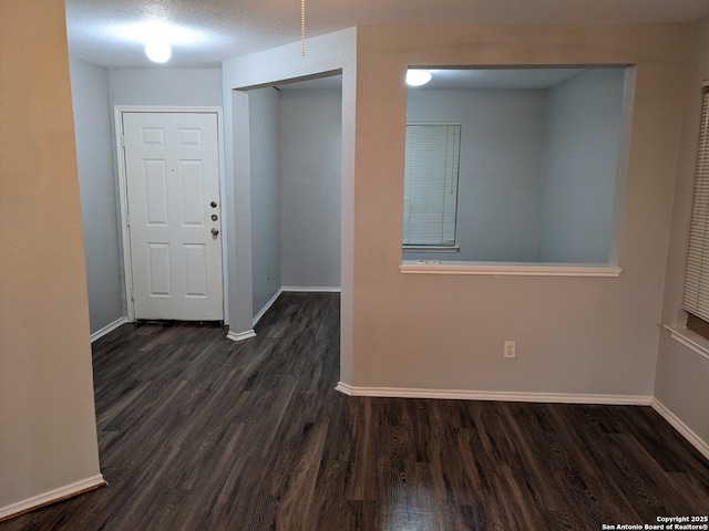 foyer entrance with dark hardwood / wood-style floors and a textured ceiling