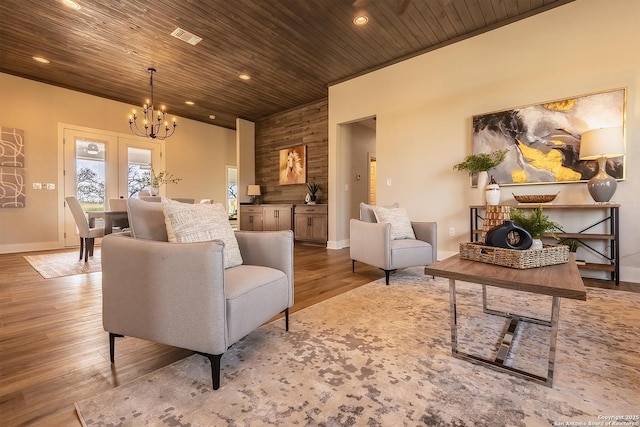 living room featuring french doors, a chandelier, hardwood / wood-style floors, and wooden ceiling