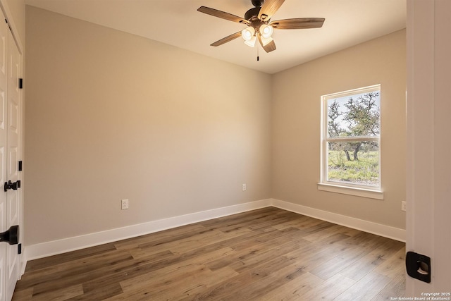 empty room with ceiling fan and dark hardwood / wood-style flooring