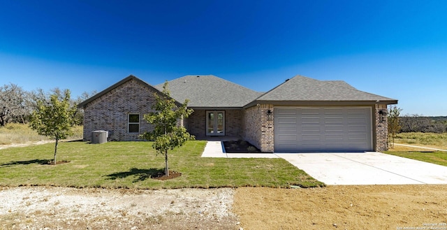 view of front of house featuring central AC unit, a garage, and a front yard