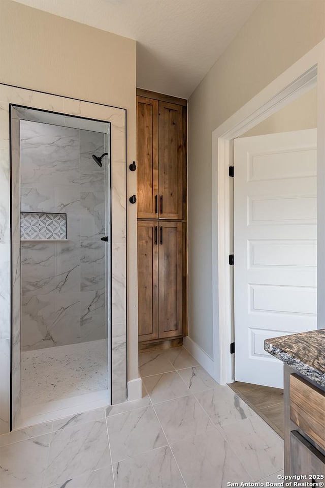 bathroom featuring tiled shower and vanity