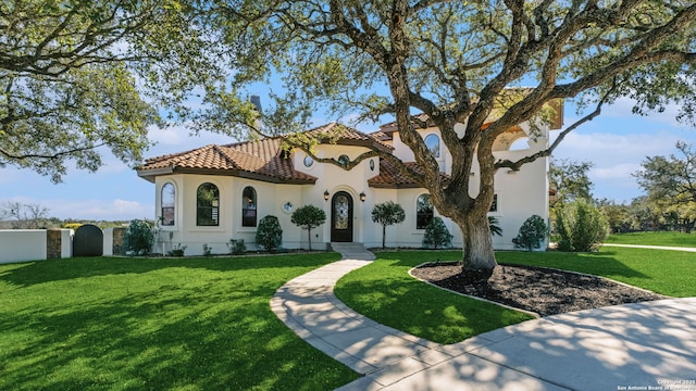 mediterranean / spanish-style home featuring a front lawn