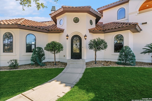 mediterranean / spanish home with a front lawn