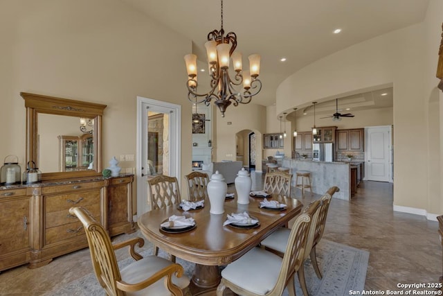 dining room with high vaulted ceiling and ceiling fan with notable chandelier