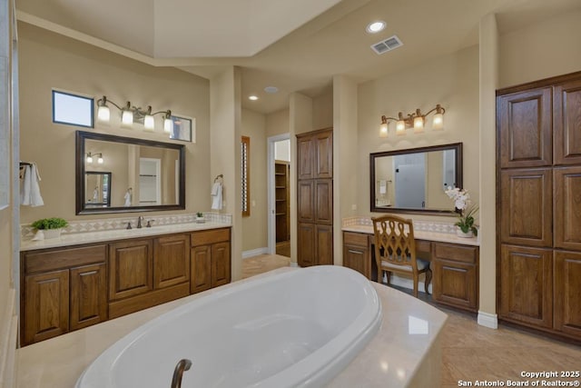 bathroom featuring vanity, tiled tub, and tile patterned floors