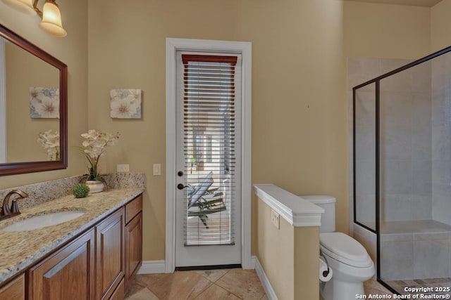 bathroom with vanity, a healthy amount of sunlight, an enclosed shower, and toilet