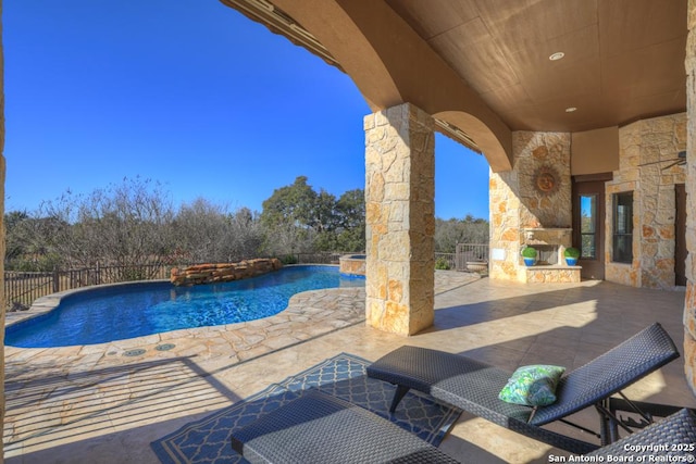 view of pool with an outdoor stone fireplace and a patio area