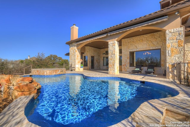 view of pool with a hot tub and a patio