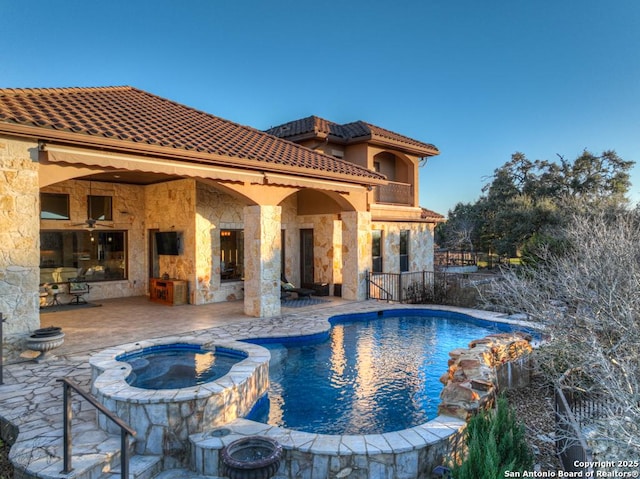 view of swimming pool with a fireplace, a patio, and an in ground hot tub