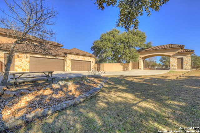 mediterranean / spanish house with a garage and a front lawn