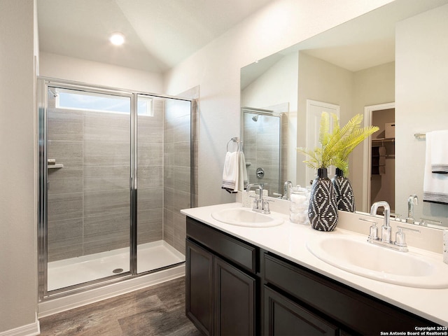 bathroom featuring lofted ceiling, vanity, hardwood / wood-style flooring, and a shower with shower door