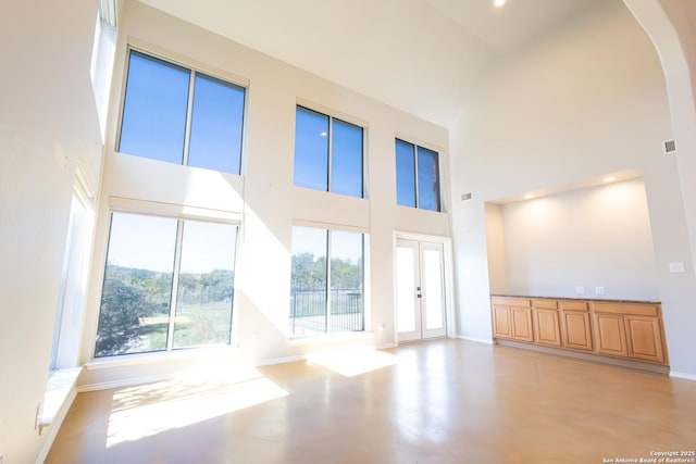 unfurnished living room with a towering ceiling