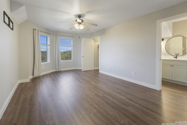 unfurnished bedroom featuring sink, dark wood-type flooring, connected bathroom, and ceiling fan