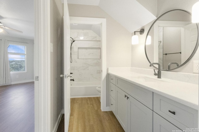 full bathroom with wood-type flooring, vanity, tiled shower / bath combo, ceiling fan, and toilet