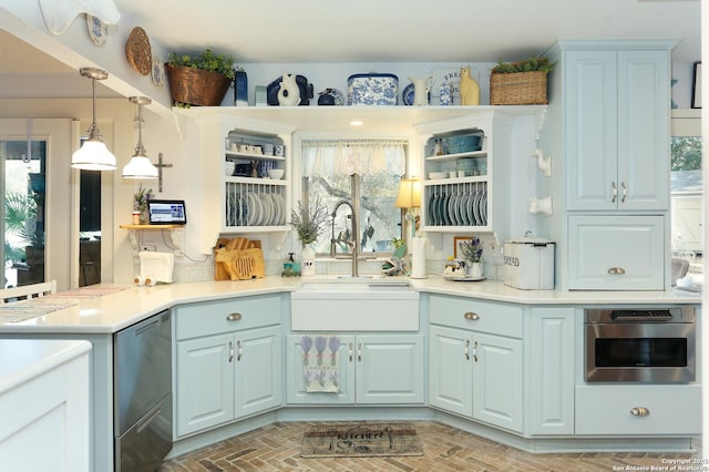 kitchen featuring sink, plenty of natural light, kitchen peninsula, decorative light fixtures, and oven