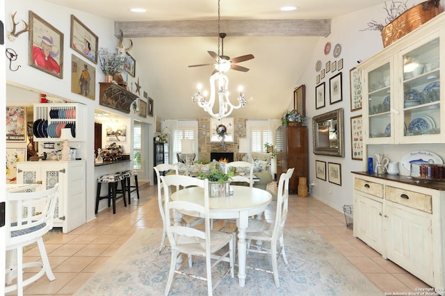 dining room featuring high vaulted ceiling, light tile patterned floors, a large fireplace, beamed ceiling, and ceiling fan