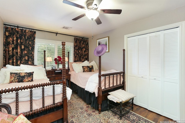 bedroom with dark wood-type flooring, ceiling fan, and a closet