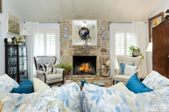 living room featuring lofted ceiling and a fireplace