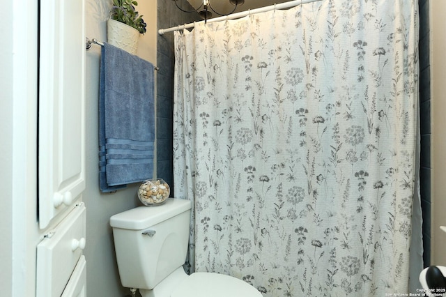 bathroom featuring a shower with curtain and toilet