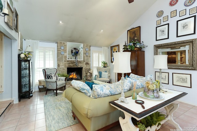 tiled living room with lofted ceiling and a stone fireplace